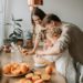 Husband and wife cook in the kitchen with their children