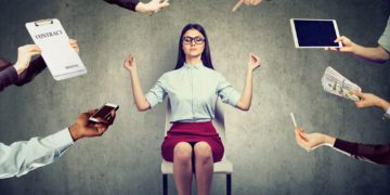 Young business woman is meditating to relieve stress of busy corporate life