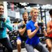 Group of young people fit friends doing exercises in gym