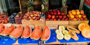 Watermelons, melons, strawberries, peaches, pumpkins, and pineapples are available at the fruit stand.