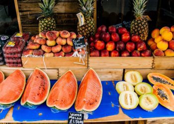 Watermelons, melons, strawberries, peaches, pumpkins, and pineapples are available at the fruit stand.