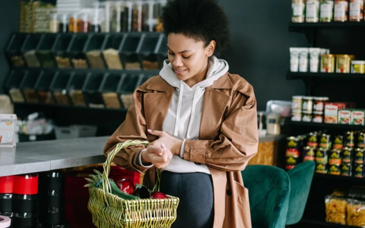 Pregnant woman shops for fresh vegetables at an organic grocery store.