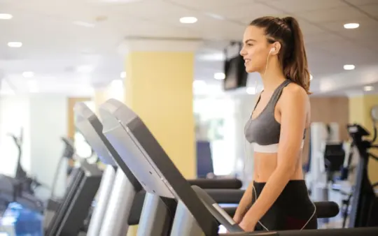 Woman enjoying a workout on a treadmill indoors, promoting fitness and health.
