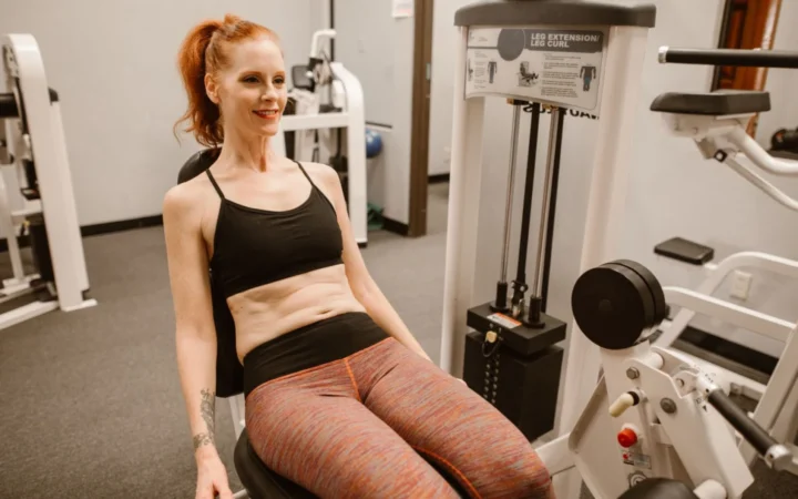 Woman performing leg workout in gym, showcasing fitness and health lifestyle.