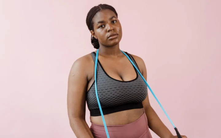 Young woman in stylish activewear using a resistance band during a workout session.