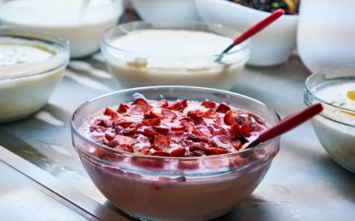 Variety of homemade yogurt dishes with fresh fruit toppings in bowls, perfect for breakfast or a healthy snack.