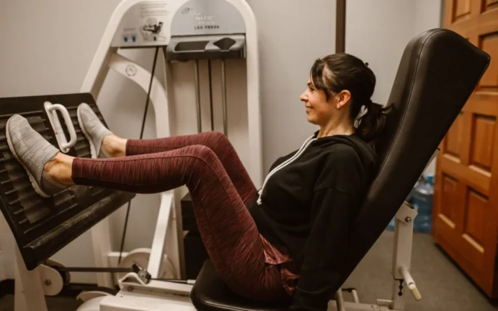 Woman works out on a leg press machine, promoting fitness and a healthy lifestyle