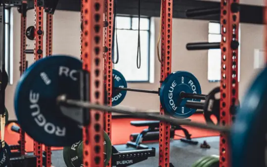 Close-up view of gym equipment with barbells and weight plates, perfect for strength training enthusiasts.