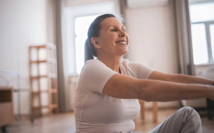 Happy senior woman exercising indoors, promoting active and healthy lifestyle.