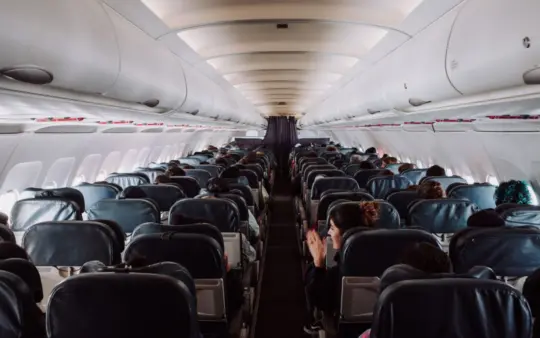 View of passengers seated inside a commercial airplane cabin during flight.