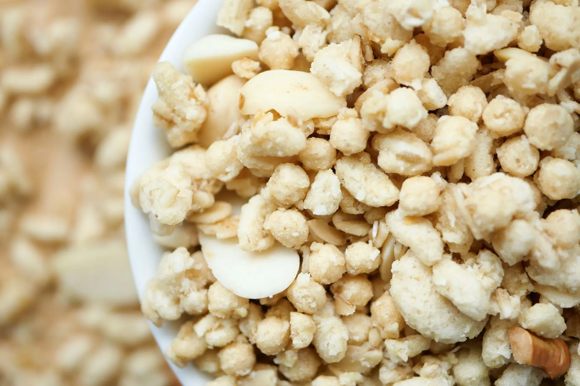 A high-resolution close-up of a bowl filled with crunchy cereal and nuts, emphasizing texture