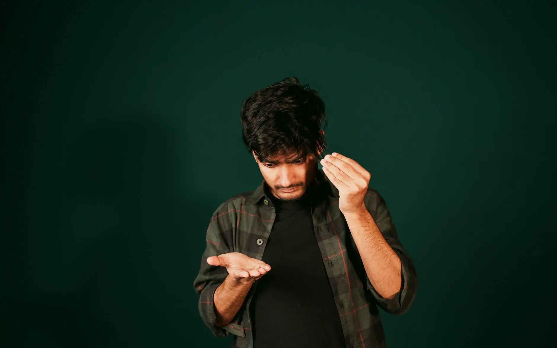 A young man examining hair loss indoors, reflecting self-care concerns