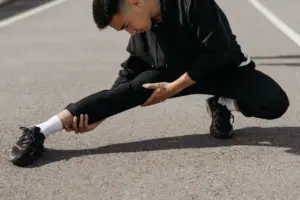 Sciatica stretch exercises: a young man performs stretching exercises on a city street, focusing on flexibility and fitness