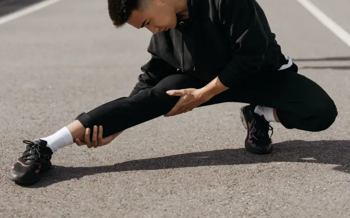 Sciatica stretch exercises: a young man performs stretching exercises on a city street, focusing on flexibility and fitness