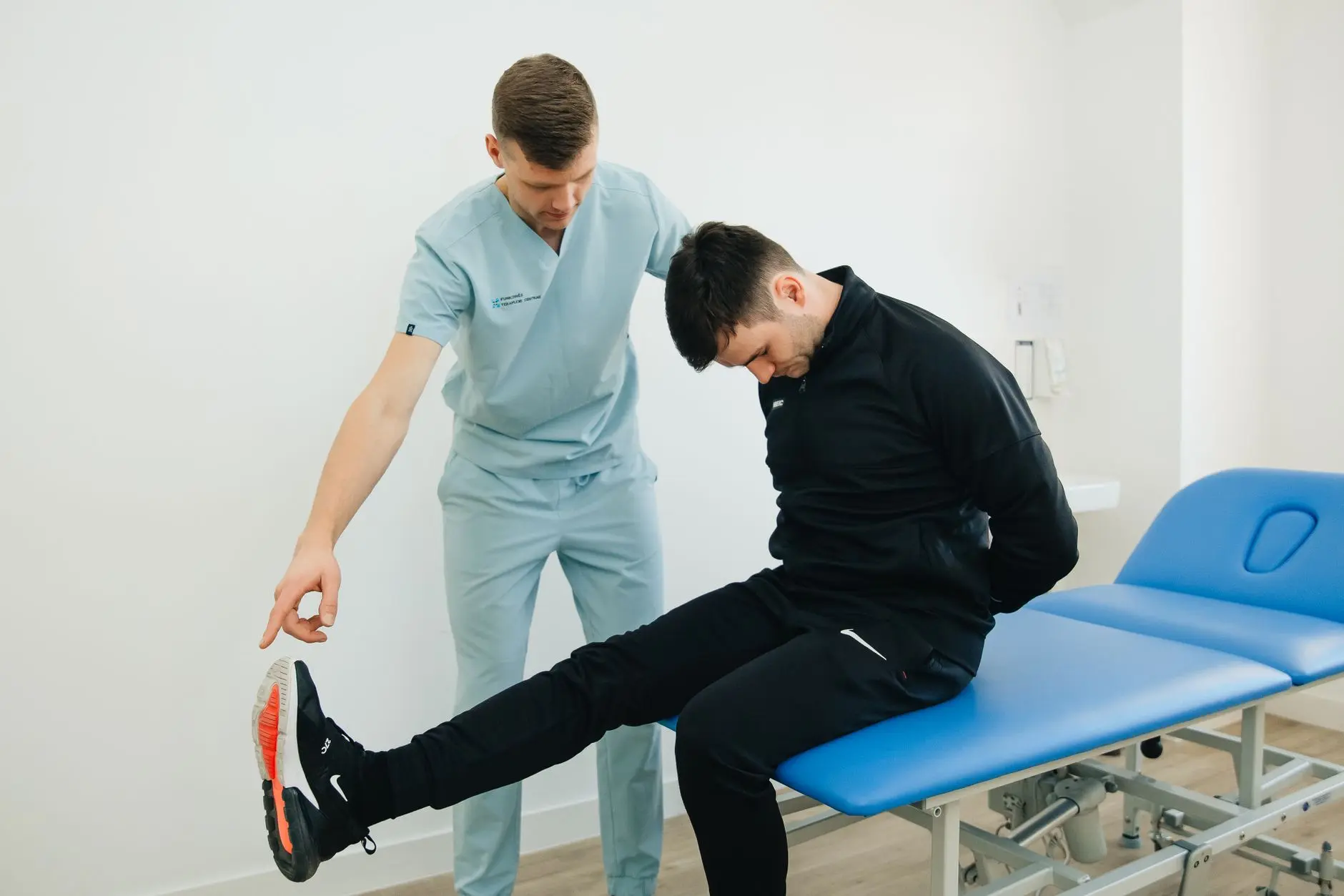 Physiotherapist instructing a patient on rehabilitation exercises in a clinic setting
