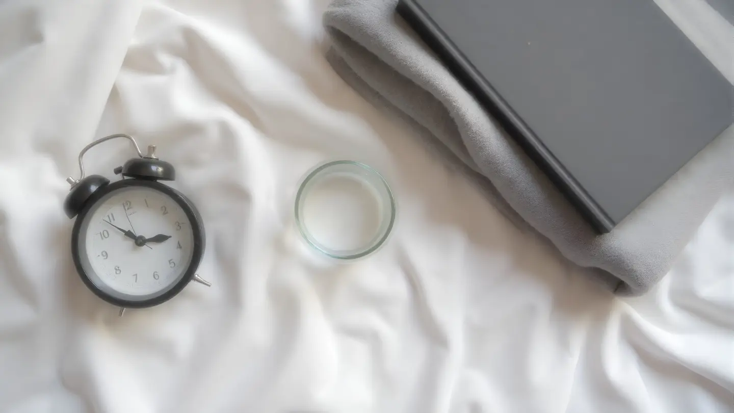 Seen from directly above, filling the frame, on a pale linen sheet: an analogue alarm clock with a plain face, a closed , generated illustration
