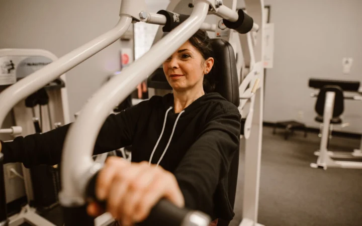 Woman working out on gym equipment focusing on fitness and a healthy lifestyle.