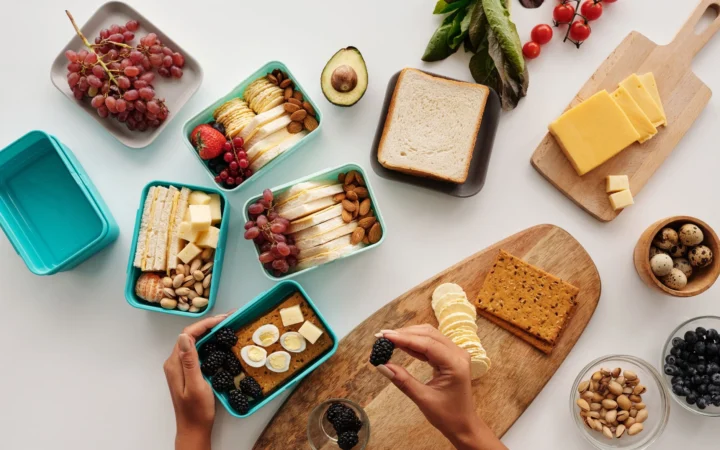 Top view of fresh and nutritious meal preparation with various fruits, nuts, and cheeses.