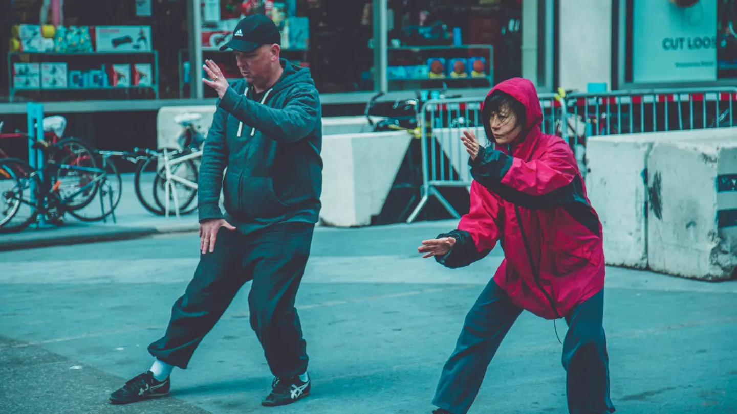 What is tai chi walking for weight loss: two adults practicing martial arts on the street, showcasing fitness and focus in