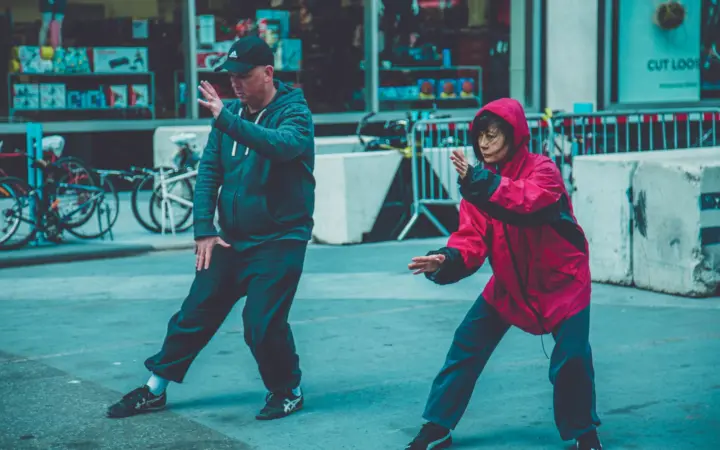 What is tai chi walking for weight loss: two adults practicing martial arts on the street, showcasing fitness and focus in