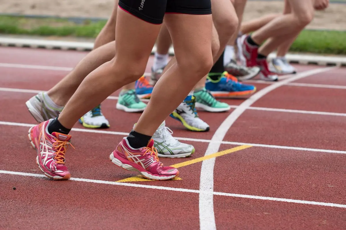 Close-up of athletes' feet at the starting line, prepared for a track race