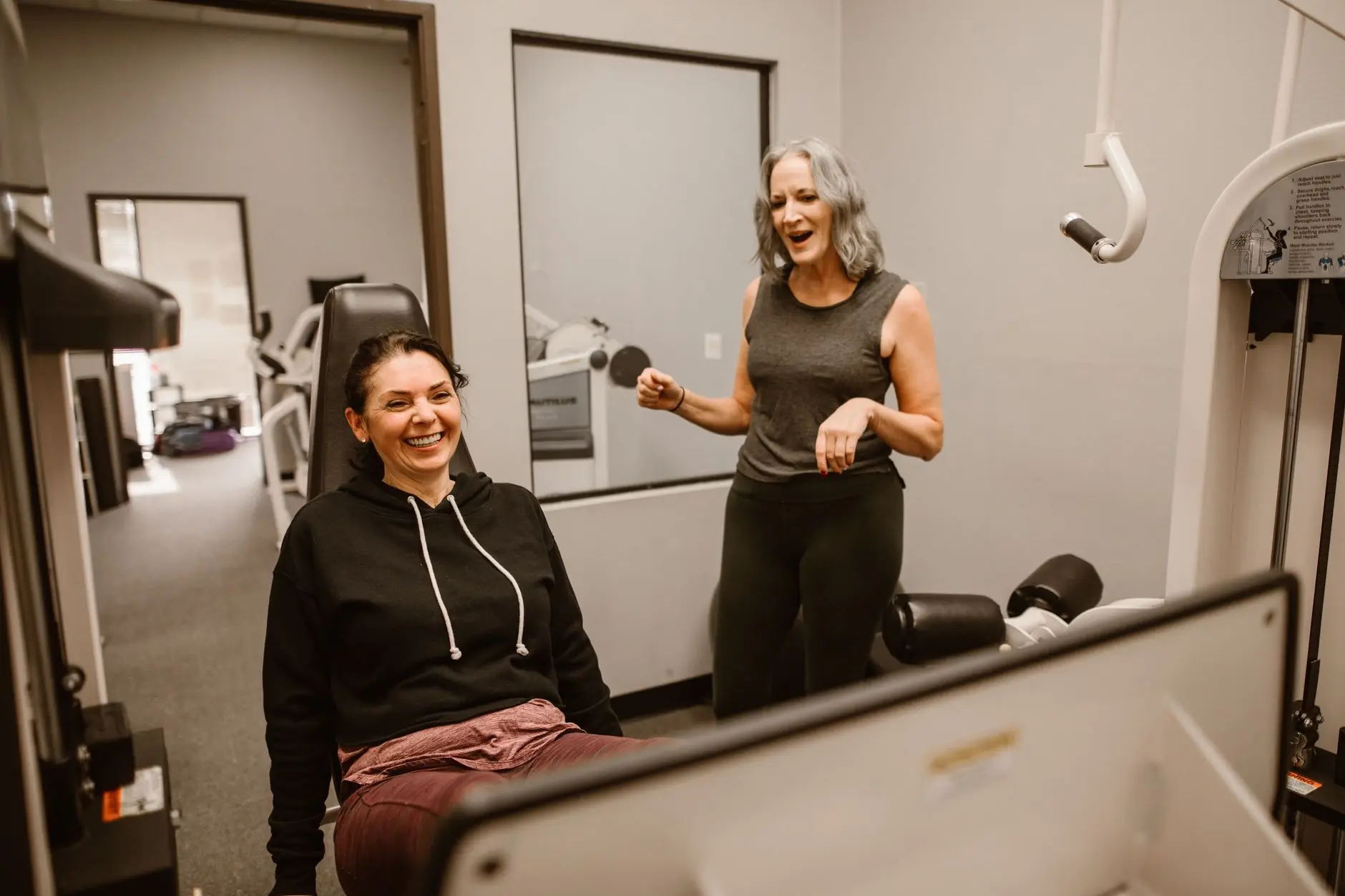 Two women enjoying a workout session indoors, promoting health and wellness