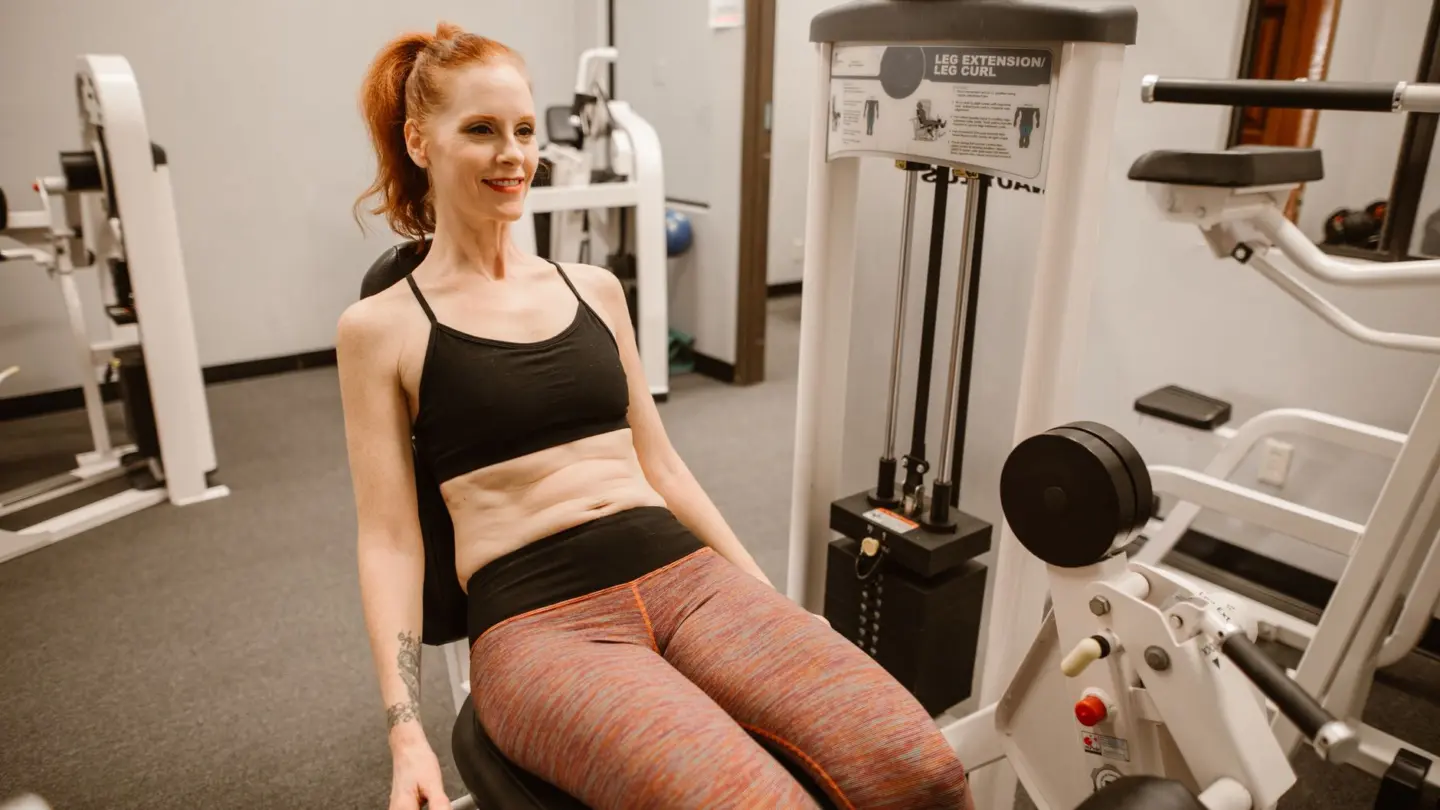 Hormone imbalance signs in women: woman performing leg workout in gym, showcasing fitness and health lifestyle