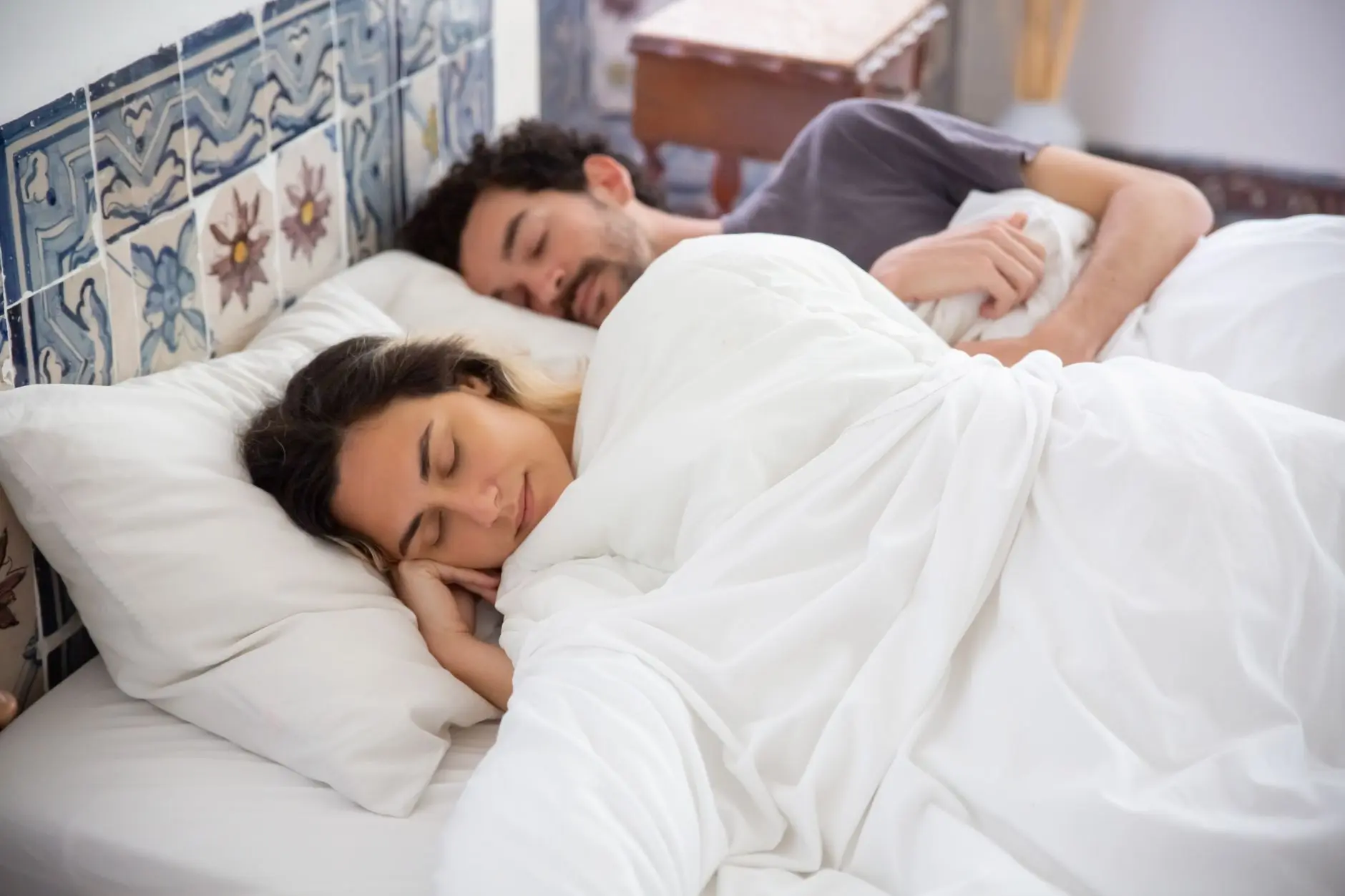 A serene image of a couple sleeping together in a cozy bedroom, capturing tranquility and comfort