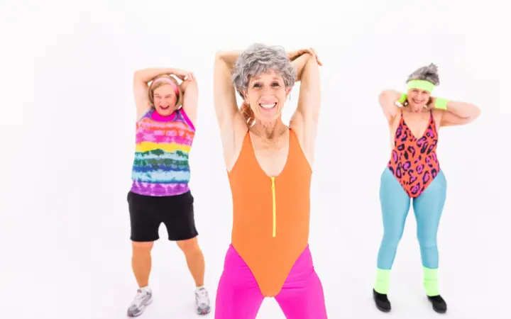 Strength training exercises for women over 60: senior women in vibrant activewear enjoying an aerobic exercise session with