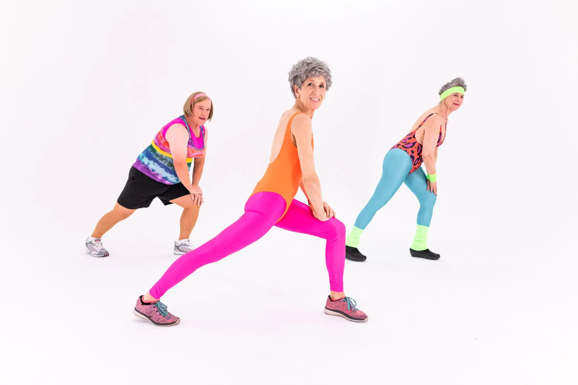 Senior women having fun while exercising in colorful activewear, promoting healthy lifestyles