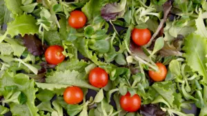 Vitamin a d e k deficiency: top view of fresh mixed greens and cherry tomatoes
