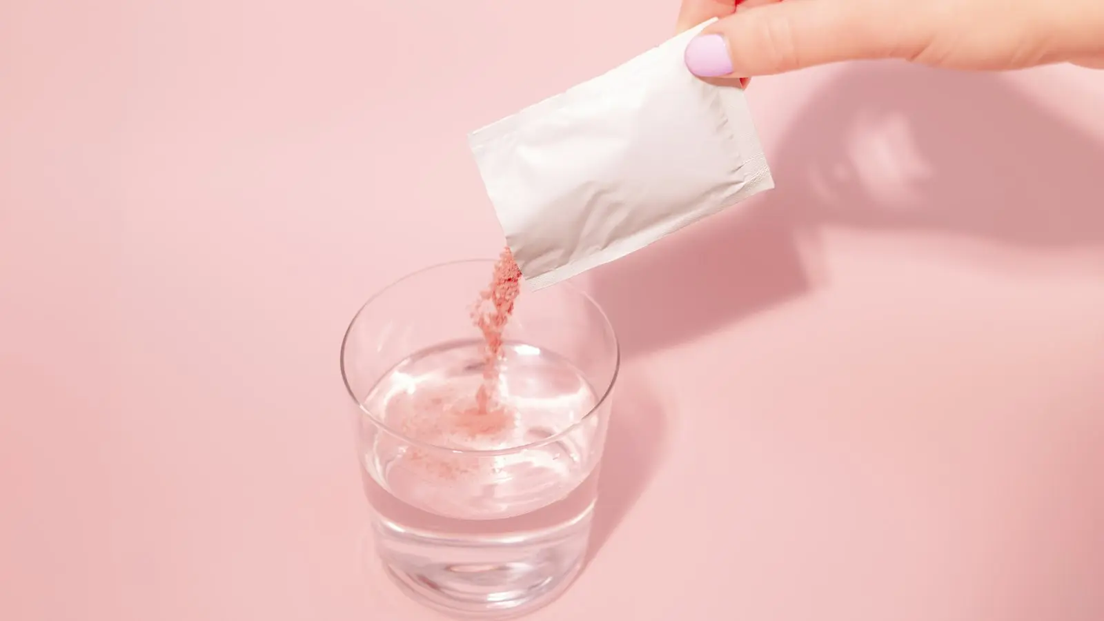 A person pouring a drink into a glass